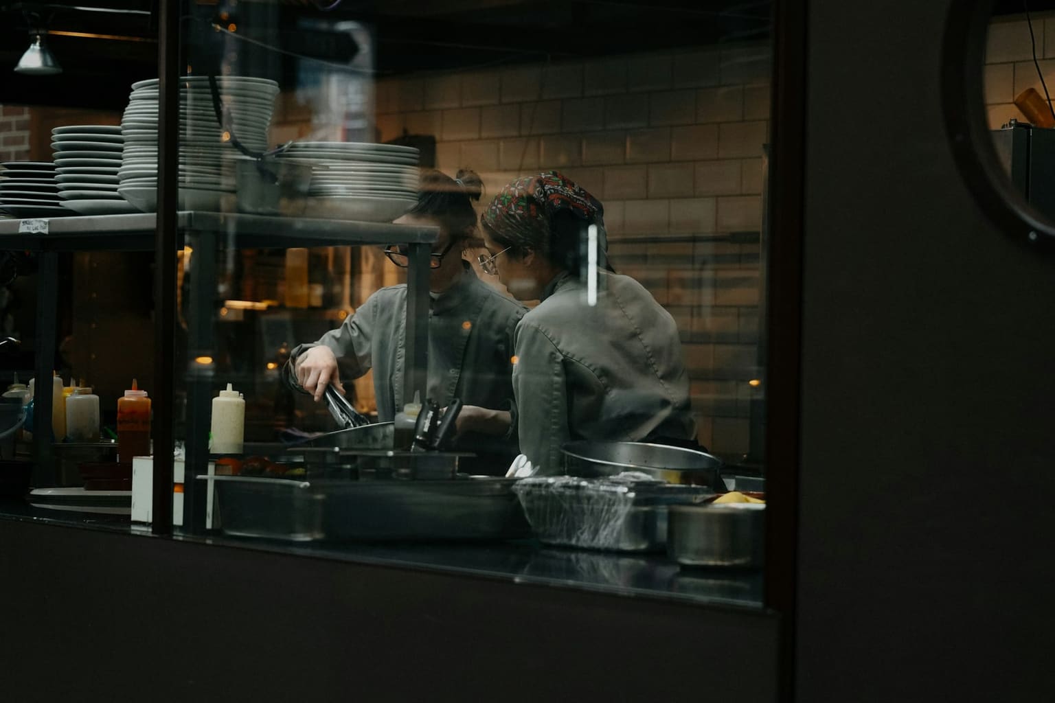 Restaurant kitchen team working together in a professional stainless steel kitchen