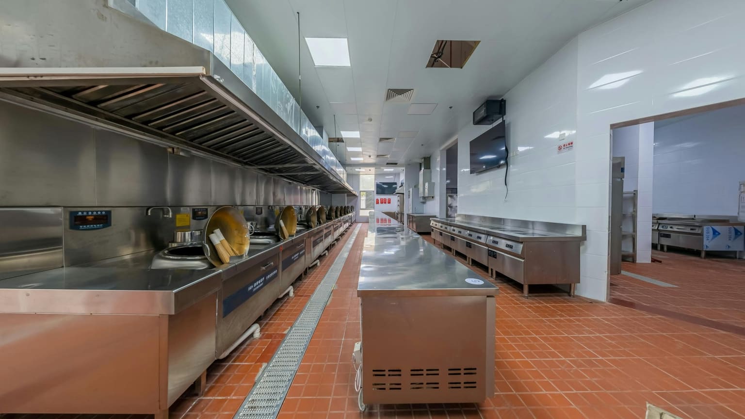 Commercial kitchen design reference showing stainless steel line and extraction canopy