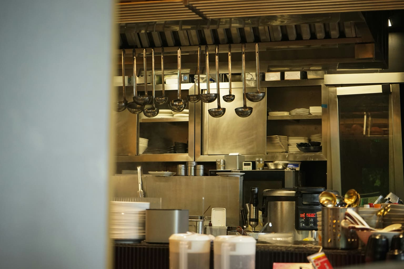 Commercial kitchen installation with stainless steel equipment and ventilation