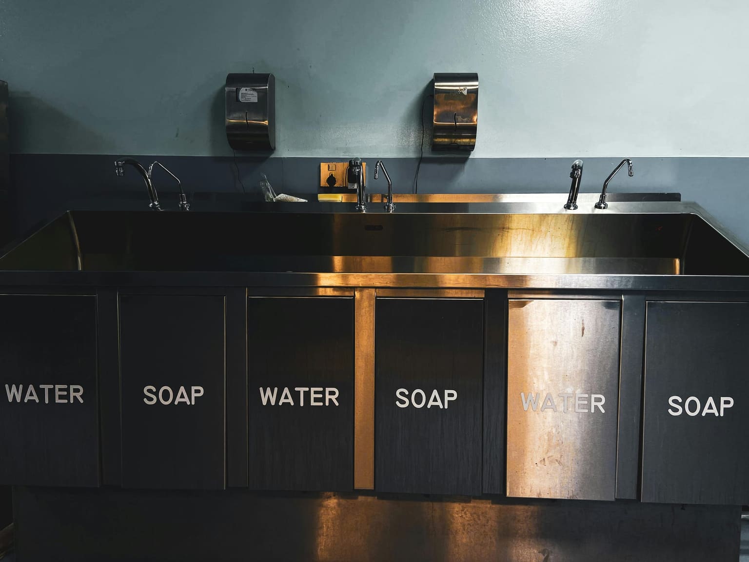 Stainless steel commercial sink and wash-up station for hygiene and maintenance workflows