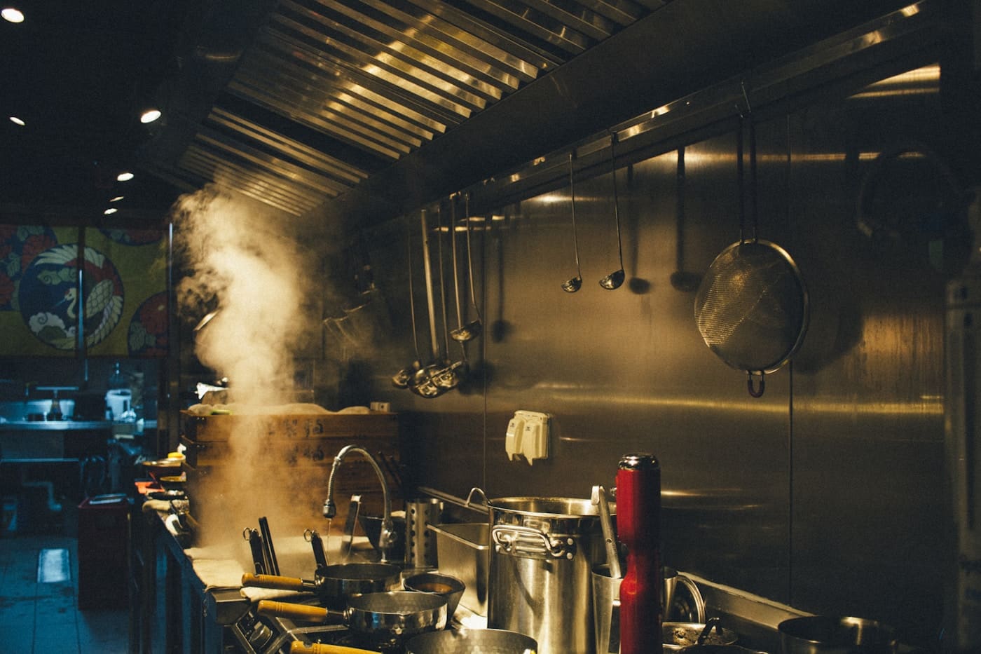 Professional commercial kitchen installation team positioning stainless steel equipment on site