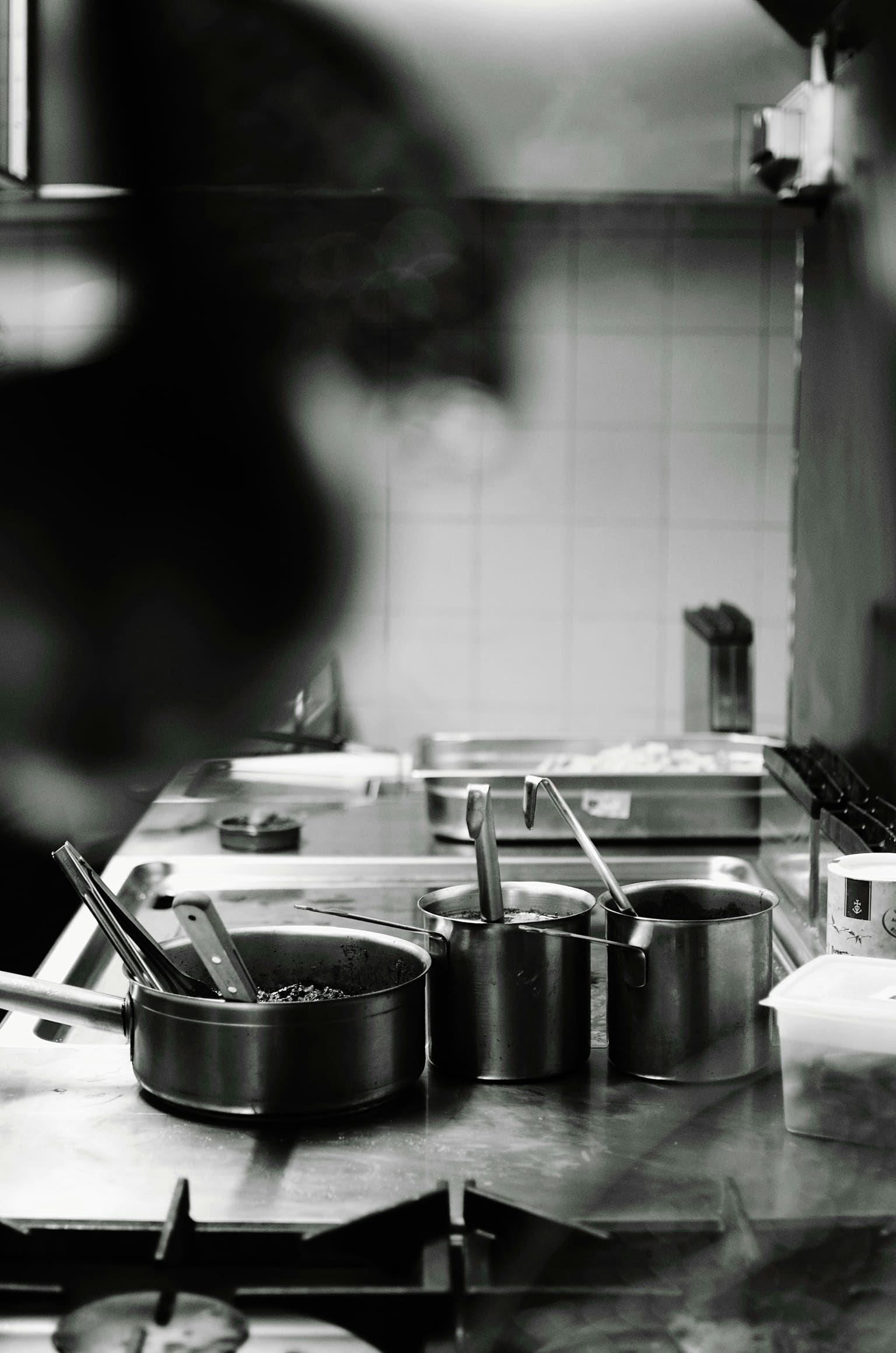 Technician servicing commercial kitchen equipment, inspecting stainless steel cooking station